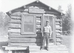 This photo from the Minnesota Historical Society collection features Harry Mathews, United States Forest Ranger, standing in front of Mulligan Forestry Cabin on the Cook County fairgrounds. It was taken around 1958.