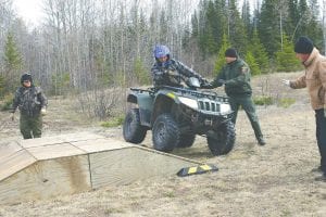 Lower Right: DNR CO Mary Manning and Tom Wahlstrom carefully oversee Devyn Deschampe as he practices riding on sloped terrain. Parker, the COs, and other volunteers set up the course the night before.