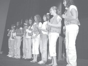 Above: Girl Scout 5th Grade Troop #4110 at the Cook County Girl Scout Court of Awards. Pictured (L-R): MaeAnna LaFavor, Haylie Anderson, Isabel Wahlers, Kimberlee Dossey, Shauna Blake, Natassja Sheils, Madison Engelhaupt. Also in the troop but not pictured is Bethany Derscheid and Kaitlin Maroney. Right: Sarah Toftey modeling a historic Brownie uniform at the