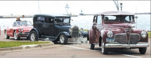 Staff photos/Laurie Johnson Top: Gleaming cars lined up next to the sparking water, then took off for a parade through the streets of Grand Marais.