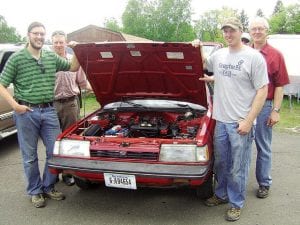 Top Left: Jonathan Hedstrom and his pit crew were on hand to answer questions about his now-electric 1988 Subaru at the Small Footprint Living Fair June 12-13, 2009 at the Cook County Community Center. (L-R) Hedstrom, Scott Sorenson, Dave Bartz, Rolf Lindstrom (hiding), and Howard Hedstrom. Above Left: Jonathan Hedstrom replaced the gas-powered engine in his Subaru wagon with an electrical system powered by batteries. The batteries will take the car about 40 miles between charges. Above middle: These gardeners came prepared for the job of constructing a rain garden behind the 4-H building at the Community Center. The project was part of the Small Footprint Living Fair that featured environmentally friendly products and practices. The rain garden is intended to prevent flooding of the 4-H building and capture runoff before it has a chance to enter city storm drains. Right, top to bottom: An interesting visitor to the Small Footprint Living Fair-  Polly Ester. 