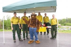 Staff photos/Rhonda Silence The Gunflint Ranger District Open House on Friday, June 19 offered insight into the many activities taking place in the Superior National Forest—now and for the last 100 years. A number of Forest Service firefighters were on hand to demonstrate the equipment used fighting forest fires—with their buddy, Smokey Bear. (L-R) Aaron Betcher, Shawn Miller, Eric Cardinal, Henyo Jeantete, Smokey, Luke Fosness, Dave Snyder, Sarah Holtzer.