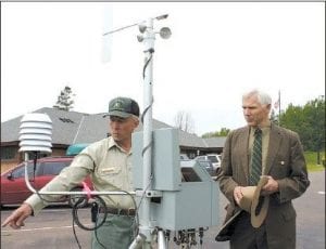 Gunflint District Ranger Dennis Neitzke, in 1950s Ranger garb, checks out some modern Forest Service technology. Dean Zeitz explained the workings of a portable weather station.