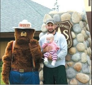 Baby Chloe Hazelton, with her dad Vance Hazelton, wasn't sure what to think of the friendly Forest Service mascot, Smokey Bear.