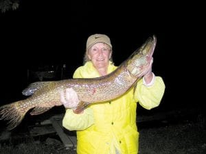 Nancy Zimmer of Grand Marais can barely hold the huge northern she caught fishing late in the evening on an area lake.