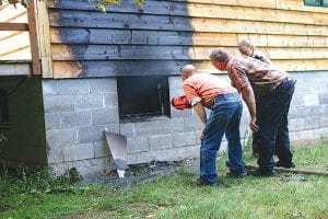 Left: Jeremy Somnis, with First Responder David Beckwith and Sheriff Deputy Julie Collman inspects damage caused to his home by the Thursday, July 2 fire. Above: Fire damage would have been much worse if it was not for the family dog, Samson, who broke off his lead and alerted the neighborhood.