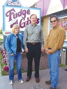 Staff photo/Jane Howard Gubernatorial candidate Matt Entenza (middle) made a campaign stop in Cook County Friday, July 24, 2009. With him was long-time friend Julie Munger of Duluth (granddaughter of Willard Munger, Minnesota's longest-serving state representative) and his host, Bill Hansen of Sawbill Lodge. To support the local economy, they made sure to buy some fudge at Beth's Fudge in Grand Marais.