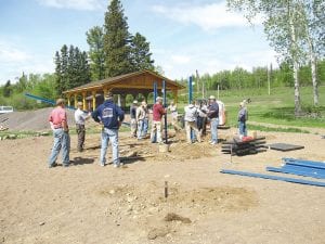 Photos by Marland Hansen Let's play! Playground assembly volunteers gathered on Saturday, June 6 to build a playground at the Lutsen Grandview Town Park. Above: Community volunteers assemble the town park playground.