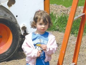 Left: Little Alessandra Duclos, 3, watches the activity, looking forward to playing on the new playground.