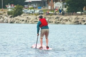 Below: Eric Humphrey of Grand Marais enjoyed the races while paddle boarding in the harbor.