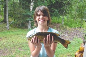 Photo by Sara Silence Courtney Koeneke, 9, of Antioch, Illinois was in third place in Buck's Big Fish Contest for a few days with the nice 13-inch small mouth bass she caught at Pike Lake. Courtney was fishing with friends at Evangelical Free Church Vacation Bible School.