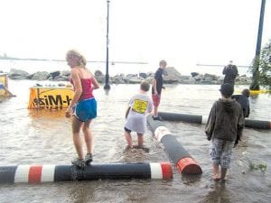 Photo by Julie Collman Upper left: When the street flooded at the Wood-Mizer Lumber Camp, kids had a great time wading and log rolling! Staff photo/AndyBrostrom Lower left: Rain dampened, but didn't stop Fisherman's Picnic activities.