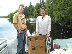 Photos courtesy of the rescuers Above: John Oberholtzer (left) and Pat Vaughn with the loon-in-a-box. Upper right: The loon was relatively calm once it was placed in the box for transport. Lower right: The loon appeared healthy—and happy—once it was released on Caribou Lake.