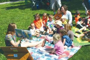 Staff Photo/Rhonda Silence Left: In June, local Daycare kids visited the library to hear Anne Prinsen read some stories. She delighted the kids from the Cooperation Station and KinderTots Daycare with Shoo, Fly, Shoo and a story about clouds.