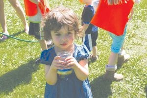 Staff Photo/Rhonda Silence Below Middle: After hearing the story about clouds, the daycare kids participated in crafts. Allessandra Duclos, 3, shows the 