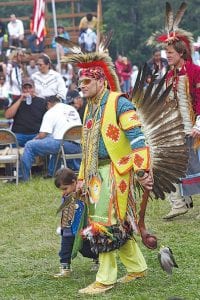 Passing down the tradition—young dancers walk beside parents and elders to learn PowWow customs.