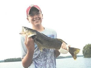 Photo by Joe Carlson Mitchel Black of Waterloo, Iowa, had the misfortune of burning his hand cooking hotdogs over a campfire, but he had great luck fishing! He is pictured here with one of the fish he caught with Joe Carlson of Joe's Inland Fishing. Mitchel caught 14, 16, 17, 22 and 24-inch walleyes and several small mouth bass, ranging from 14 -  17 inches.