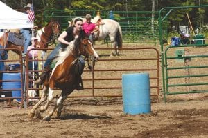 Staff photos/Laurie Johnson The Sawtooth Mountain Saddle Club had its first event in the Gunflint Horse Park during the 2009 fair. Top: Marybeth Wilkes rounding the second barrel in the barrel race competition. Above left: Philis Anderson in the driving competition with her Fjord horse. Above right: John Ofjard and his Norwegian Fjord horse wait for their turn in the 