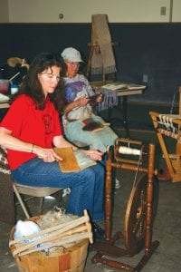 Staff photo/Laurie Johnson Kay Rosenthal and Linda Bauer carding wool to spin at a Northwoods Fiber Guild demonstration at the fair on Saturday, August 22.