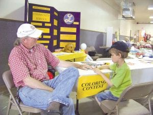 Photo by Sandra Hyne Garry Gamble of Grand Marais and his grandson, Elijah Zupfer, enjoy some time together the Grand Marais Lion and Lioness booth at the Fair. Elijah was one of 36 kids who entered the Lion Coloring Contest.