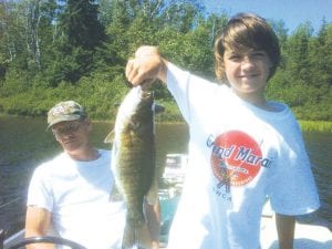 Photo courtesy of Joe Carlson Miles Hussey of North Branch, MN with the largest of the five small mouth bass caught while fishing on one of our rare summer days with Joe Carlson of Joe's Inland Fishing.