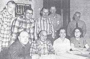 Studying architects' preliminary drawings of the North Shore Hospital are some of the N. S. Hospital Board members who met recently. Seated left to right: Sherman Benson, Chairman; H. T. Stickney; Mrs. Mervin Bower; Mrs. Thomas Allard; Standing, Dr. Richard Soderberg, Wesley Backlund, Albert Almlie, W. Andrew Hedstrom, and Val Dalbec. Absent when the photo was taken were Janet Hanson, Mrs. A. A. Gilchrist and Arthur Eliasen.