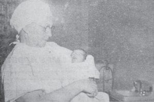 Above: Nurse Mrs. Fred Arnold holds Patricia Jan Eckel, the first baby to be born at the North Shore Hospital.