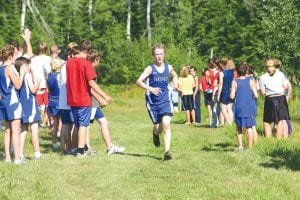 Left: Junior high girls in the gold! Signe Larson (left) ran a solid 11:24 for second in the girls' race, working off some rust from a summer of relative inactivity. Rose Ingebrigtsen medaled in ninth place with a 12:17 in her first race at Pincushion Mountain on September 3. Above Left: Freshman Kieran Scannell led the Vikings with a sixth place finish, running 19:19 in the boys' varsity 3.1 mile race. Above Right: Sonja Peterson was the first Viking across the finish line in the varsity girls' race earning fifth place in 17:04 at the Viking Challenge Invitational on Thursday, September 3.