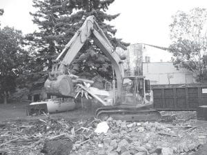 Staff photo/Jane Howard Aaron Smith with George Humphrey Contracting clears away what was left of the little red building off the alley between City Hall and Sven & Ole's. The building, most recently home of Superior North Outdoor Center (otherwise known as the bike shop), was torn down Friday, August 21, 2009.