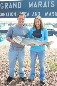 Photo by Cathi Williams Parker and Melissa Torkelson from Park Rapids, MN, honeymooning in Grand Marais, spent a day fishing with the Fishin' Chics and Captain David Williams. Melissa was reeling in the fish and it was bigger than she could handle, so she passed it off to her new husband and he landed it. It weighed 12 pounds 2 ounces and was just one of four nice lake trout they caught.