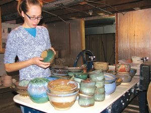 Photo courtesy of Grand Marais Art Colony Holly Johnson Beaster surveys hand-made bowls for Empty Bowls, an annual fundraiser for the local food shelf, happening on Thursday, November 12 from 5-7 p.m. at the Congregational Church. Interested in creating a bowl for the event? There are many opportunities to do so; contact the Art Colony at (218) 387-2737 for more information.