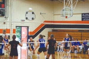 Photos by Jean Mathis Top: Brea Boomer digs while teammates Essa Jacobsen and Ashley Deschampe anxiously wait to assist. Above: Seniors Essa Jacobsen, Carly Puch and Christina Nelson strategize.