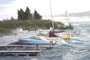 Staff photo/Rhonda Silence Extremely high winds pounded the Grand Marais harbor, sinking boats by the Coast Guard station and tearing trees up by their roots on Monday, September 28. See more storm photos on page A3.