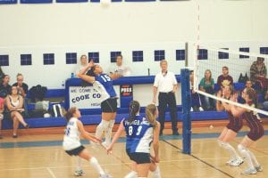 Staff photo/Laurie Johnson A determined Christina Nelson prepares to return a hard volley from the Barnum Bombers at the September 22 home game. Waiting to assist are teammates Kristina Rude and Brea Boomer and libero Samantha Jacobsen.