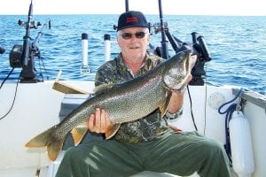 Photo by Darren Peck John Zollars is one of the four “Throttle Jammers” who fish with Captain Darren Peck of Tofte Charters each season. He is pictured with the 11.5-pound lake trout he caught on September 23.