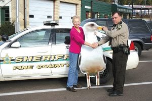 Staff photo/Jane Howard Diane Brostom, director of the Grand Marais Area Tourism Association, accepts a stolen gull from Pine County Sheriff Deputy Daniel Kunz. Kunz brought the gull to Grand Marais Monday, October 5, 2009 after a tip from someone he had in custody led to someone who had access to it. The bird, which had disappeared in July, was part of a billboard advertising Grand Marais along I-35.