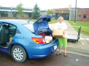 Photo courtesy of the school School District 166 math teacher Kaye Tavernier loads used math textbooks in her car for the Books for Africa program.