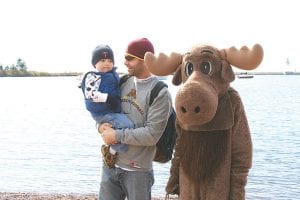 Staff photo/ Rhonda Silence The weather was nice for a walk along the Grand Marais harbor. Chad and Theo took a break and visited with Murray.