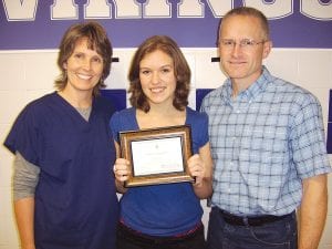 Staff photo/Jane Howard CCHS senior Karlee Axtell (center) with her parents, Denise and Treg Axtell, after she received a commendation from the National Merit Scholarship Corporation for her high score on the 2008 Preliminary Scholastic Aptitude Test (PSAT ). The award was presented to her by Principal Gwen Carman at CCHS Monday, November 2, 2009.