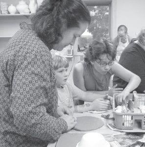 Photos by Amy Demmer Above: Jane Howard and her children, Adrian and Wellesley Howard-Larsen, work on their bowls for the Empty Bowls 2009 fundraiser. Their sister Paisley also made a bowl. They were among the more than 50 community members who participated in Make-A-Bowl open studio sessions at the Grand Marais Art Colony this fall. Empty Bowls, which is a fundraiser for the Food Shelf, will be held at the First Congregational Church from 5-7 p.m. on Thursday, Nov. 12. Left: Korey Bockovich holds up a bowl he made and decorated for Empty Bowls 2009 at the Art Colony. He and other youngsters were part of the Stone Soup Gardeners, who grew vegetables at the WTIP Community Garden this year to use in a soup for the fundraiser Nov. 12.