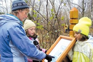 y Birch Grove Community School celebrated the completion of its new nature trail system behind the school on October 23. Above: B.J. Kohlstedt of the Jeffers Foundation, which helped fund trail improvements, checks out the interpretive signs with students. Right: Jill Nocera, who designed the school’s new environmental education curriculum as part of her dissertation, displays the finished project.