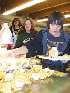 Staff photo/Jane Howard Reaching for his ala carte lunch is CCHS student Kaleb Abelon. Behind him are Katrina Axtell and Alton Danielson. Cook County Schools are trying to increase nutrition in their school lunches.