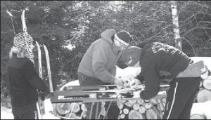 Photo by Kelly Rauzi Cross-country volunteer Burt Carlsted-Gillis and Coach Mark Summers waxing Shelby Ahrendt’s skis.