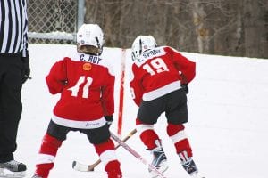 Cameron Roy defending and Ethan Sporn skating the puck.