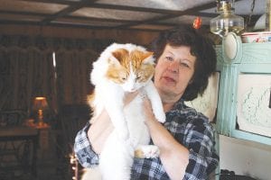 One life down? This eight-month-old male cat, Mouse Trap, with his owner, Janet Roesner, is one lucky fellow. He made his way to the top of a 20-foot power pole without harm and was rescued by Arrowhead Electric Cooperative linemen Jerry Paine and John Twiest on Wednesday, February 16.