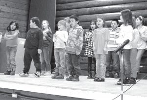 Top: On Thursday, February 11 the Grand Portage community gathered for a performance Photos by Grandpa Ranger Rick Novitsky by the students of Oshki Ogimaag charter school. The students practiced and performed their mid-winter music program at the old log school stage. The children sang eight selections, including If You Want to Sing Out, Sing Out. In addition to the songs, the children performed a traditional story narrated by Tiana Einberger, and Jayden Aubid read a poetry selection.