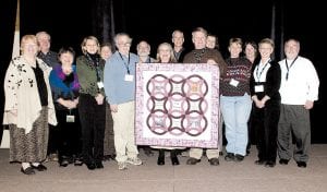 Ted Young was recognized as “Volunteer of the Year” at the recent Minnesota Bed & Breakfast Association meeting in Brainerd. Young is pictured here (sixth from left) with members of the MBBA, who presented him with this beautiful quilt.