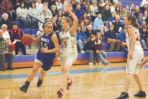 Above: Senior Christina Nelson fights her way around a Barnum Bomber to get to the hoop at the home game Right: Junior Brea Boomer struggles to maintain possession in the paint.