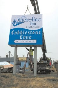 There are no records of when the original Shoreline Motel sign was erected on the corner of Highway 61 and Broadway Avenue, but many of the people who watched the old sign being taken down on Thursday, March 11 were glad to see it go. While Kevin Bjork and Brad Sarri from Todd Signs of Duluth were setting up the crane to put the new sign in place, the new and old signs sat sideby side on the ground. The new sign is 120 square feet and weighs 600 pounds. The signposts were cut nearly in half—the top of the new sign is 18 feet, which is 18 feet lower than the old, so the sign no longer towers over the town.