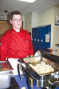 Left: Richard Selz of Papa Charlie's Tavern in Lutsen offered scrumptious oriental cuisine. Above: Lorelei Livingston, a Cook County Education Foundation board member, tries a lemon bar from The Pie Place, one of the many local restaurants who provided scrumptious sustenance for EAT S.